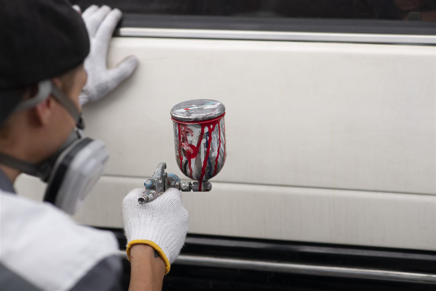 Professional spray application on a smooth exterior panel surface